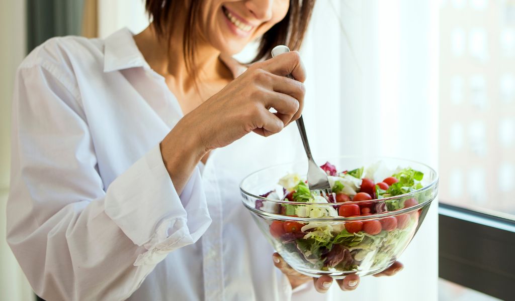 美味しそうなサラダをフォークで食べようとする女性