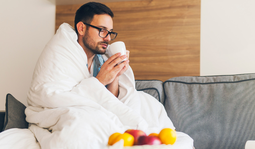 暖かくしてホットドリンクを飲む男性