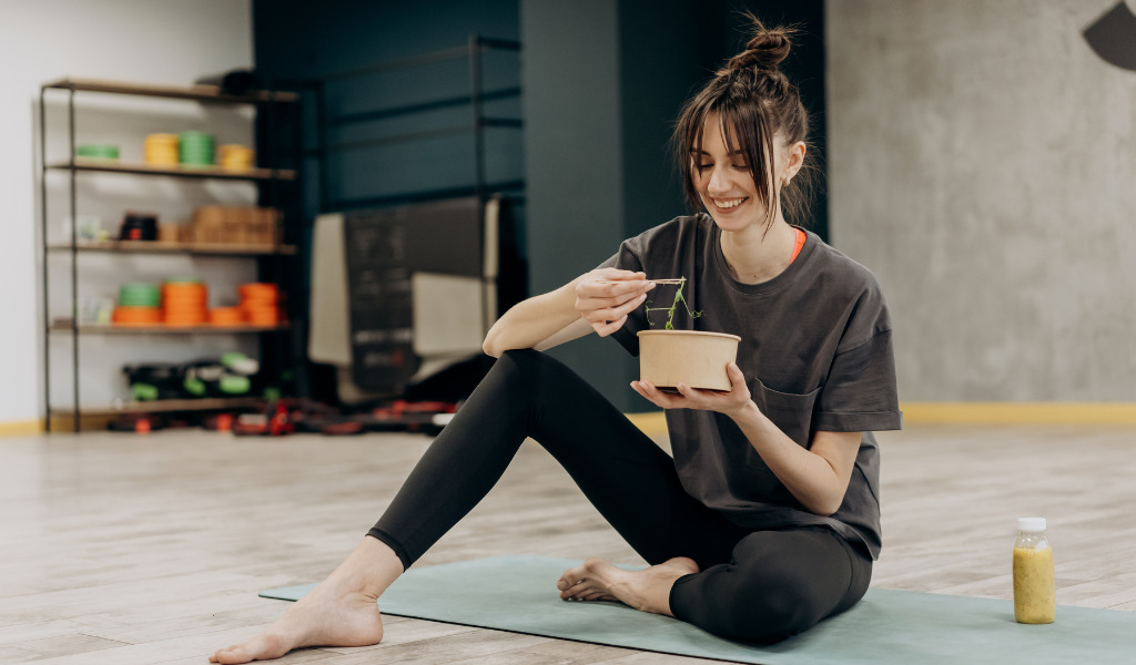 ジムで食事するトレーニーの女性