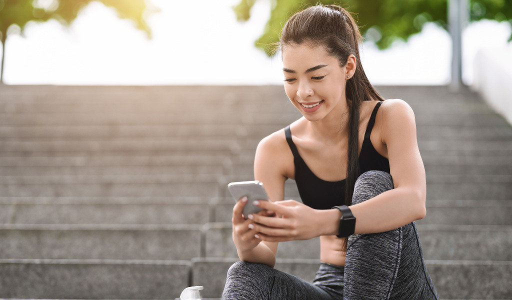 スマホを見るトレーニーの女性